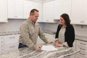 Going Over Kitchen Fit with customer in white kitchen with marble countertops.