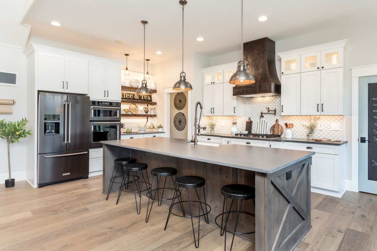 Modern kitchen remodel with white kitchen cabinets and a dark wood kitchen island.